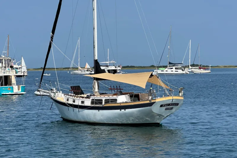 The Image of 1979 Downeast DE38 sailboat anchored in a serene harbor with other boats. - 1