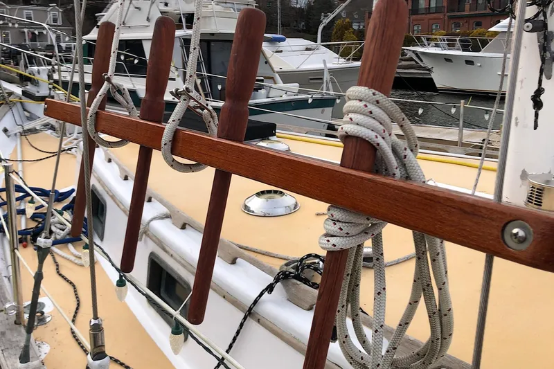 Slide: The Image of 1979 Downeast DE38 sailboat deck with ropes and wooden belaying pins. - 11