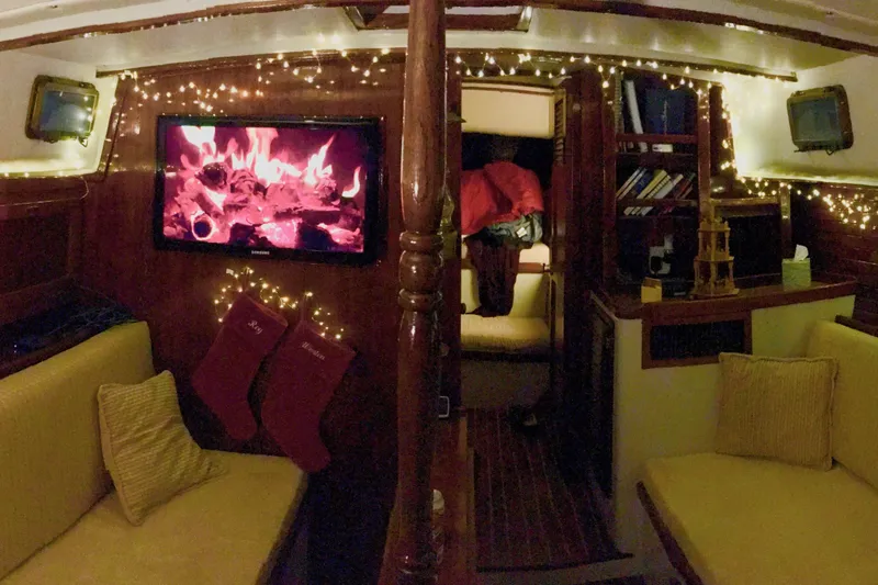 Slide: The Image of Cozy 1979 Downeast DE38 boat interior with festive lights and digital fireplace. - 12