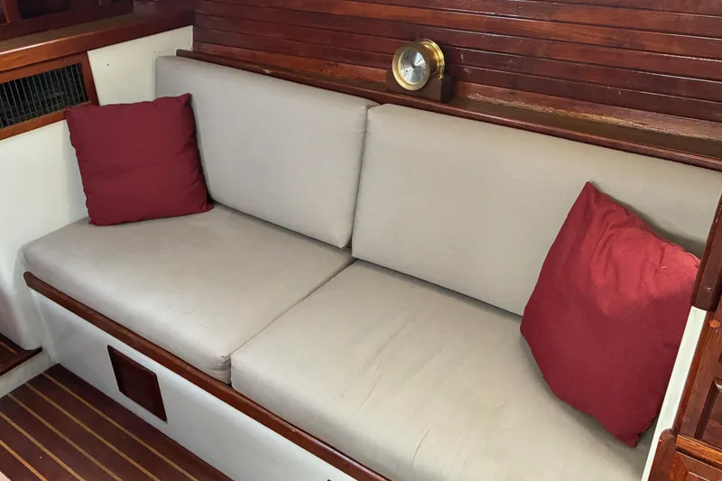 Slide: The Image of 1979 Downeast DE38 boat interior with beige cushions and red pillows. - 13