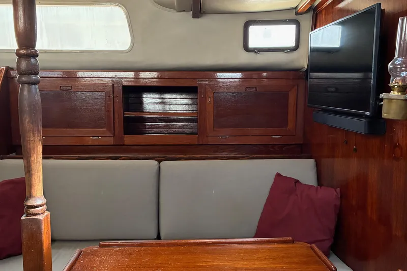 Slide: The Image of Interior of 1979 Downeast DE38 sailboat with wooden cabinetry and cozy seating area. - 14