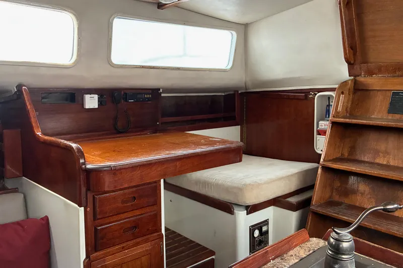 Slide: The Image of 1979 Downeast DE38 yacht interior with wooden desk and seating area. - 17