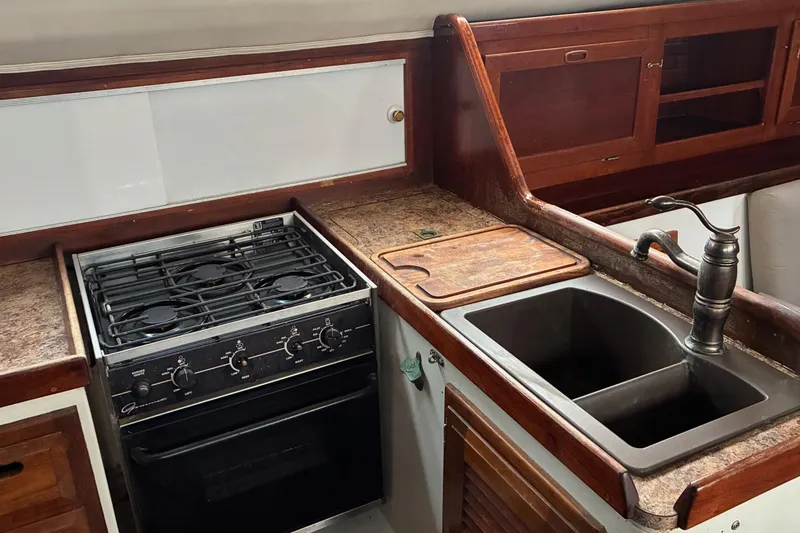 Slide: The Image of 1979 Downeast DE38 boat kitchen with stove, sink, and wooden cabinetry. - 19