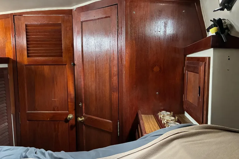 Slide: The Image of Interior of 1979 Downeast DE38 sailboat with rich wooden cabinetry and brass accents. - 20