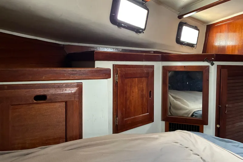 Slide: The Image of 1979 Downeast DE38 cabin interior with wooden cabinetry and portholes. - 21
