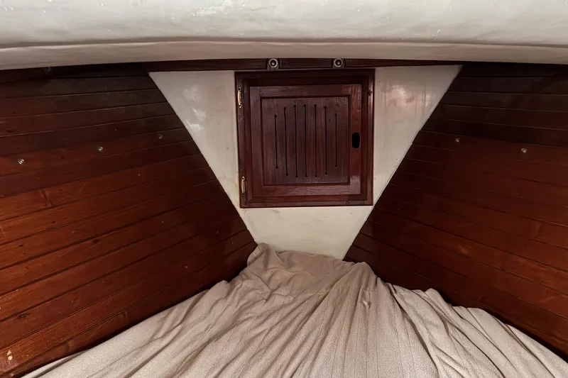 Slide: The Image of Cozy cabin interior of 1979 Downeast DE38 sailboat with wooden paneling and bedding. - 22