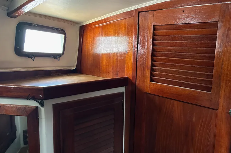 Slide: The Image of 1979 Downeast DE38 interior with wooden cabinetry and porthole window. - 26