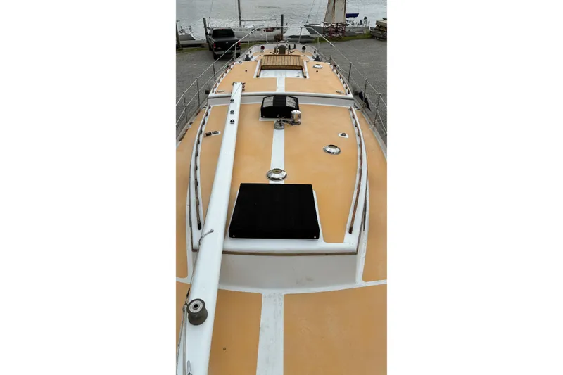 Slide: The Image of 1979 Downeast DE38 sailboat deck with tan and white design, docked near water. - 8