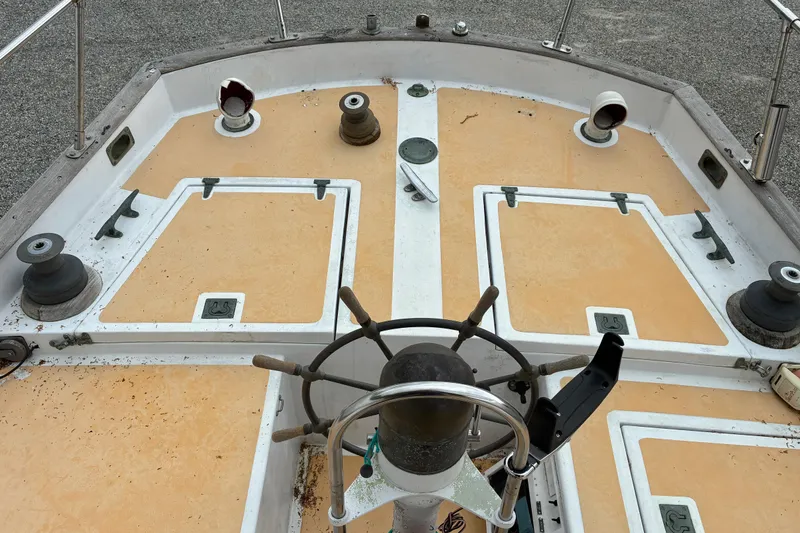 Slide: The Image of 1979 Downeast DE38 boat deck with steering wheel and hatches, showcasing nautical equipment. - 9