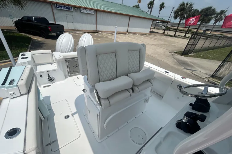 Slide: The Image of 2026 Sea Hunt Gamefish 27 Coffin Box boat interior with plush seating and steering wheel. - 12