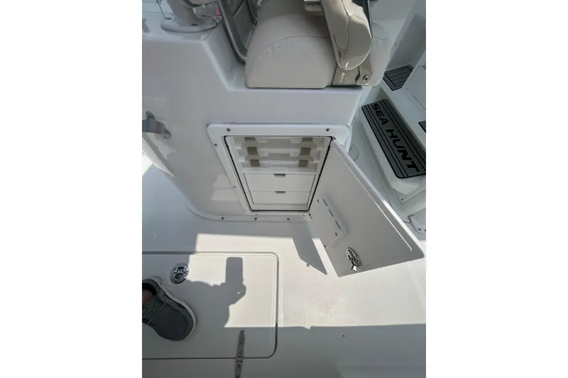 Slide: The Image of 2026 Sea Hunt Gamefish 27 Coffin Box interior storage compartment with open door. - 14