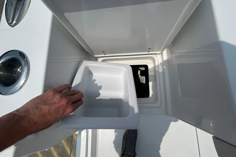 Slide: The Image of Hand opening storage compartment on 2026 Sea Hunt Gamefish 27 Coffin Box boat. - 16