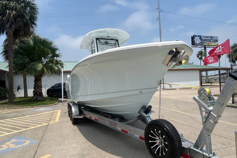 Slide: The Image of 2026 Sea Hunt Gamefish 27 Coffin Box boat on trailer, parked outdoors. - 2