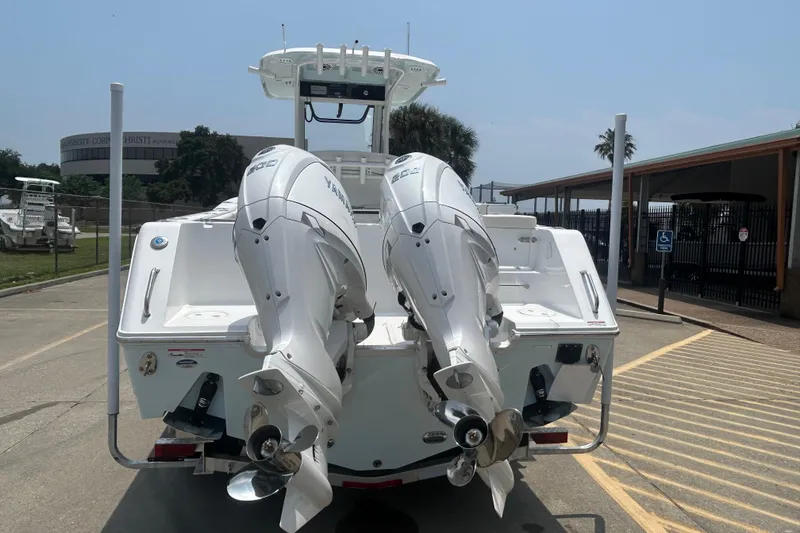 Slide: The Image of 2026 Sea Hunt Gamefish 27 Coffin Box boat with dual outboard engines, parked outdoors. - 5
