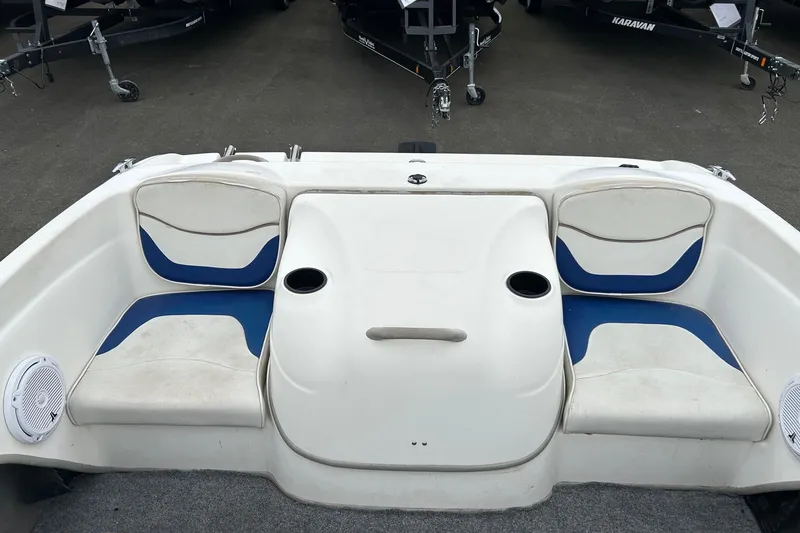 Slide: The Image of 2003 Bayliner 175 Bowrider interior with blue and white seating, cup holders, and speakers. - 11