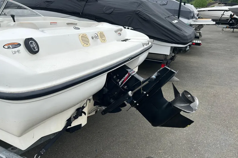 Slide: The Image of 2003 Bayliner 175 Bowrider boat with Mercury outboard motor, parked on pavement. - 2