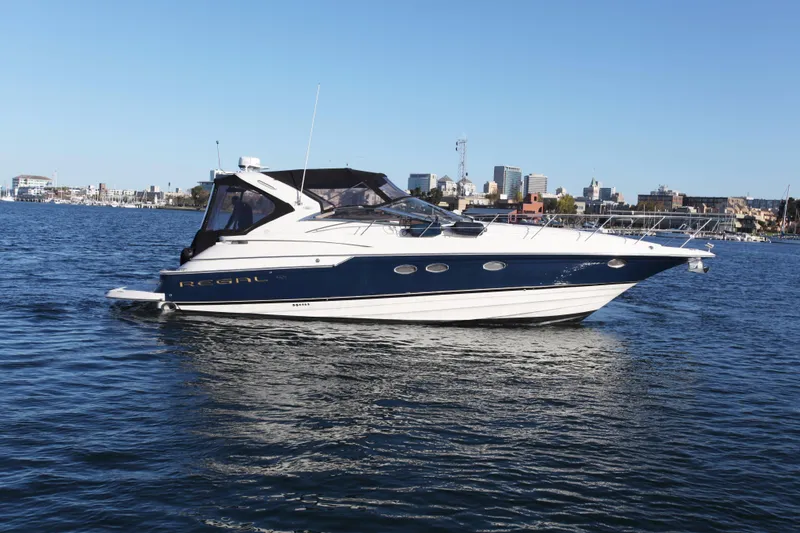 The Image of 2002 Regal Commodore 4260 yacht on calm water with city skyline. - 0