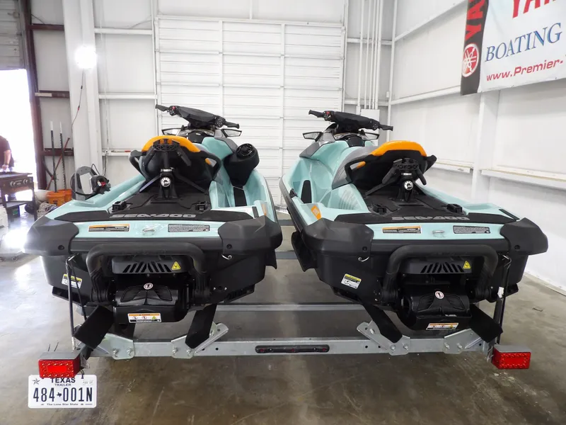 Slide: The Image of Two 2023 Sea-Doo Wake 170 jet skis on trailer in warehouse. - 11