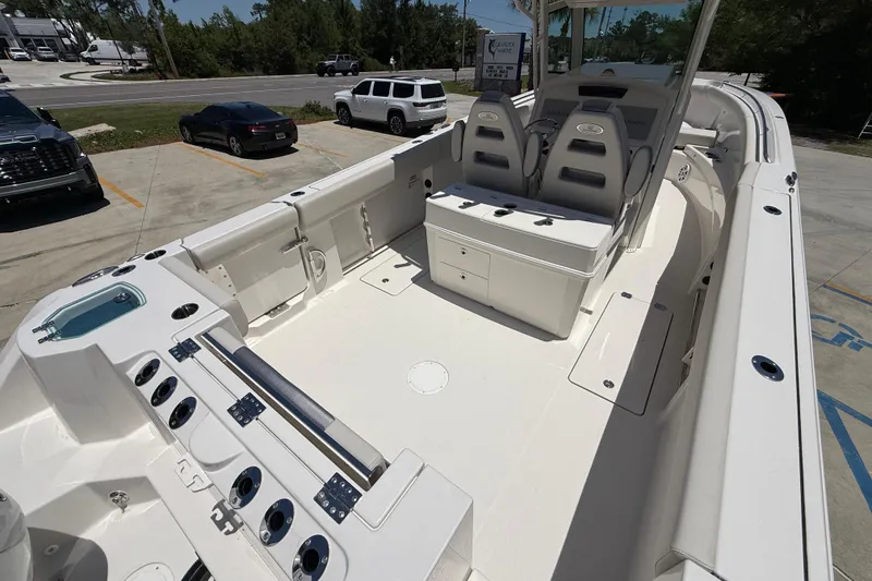 Slide: The Image of 2026 Sailfish 312 CC boat interior with seating and storage, parked in a lot. - 10