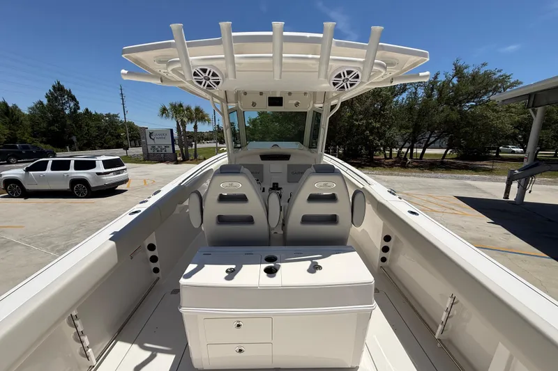 Slide: The Image of 2026 Sailfish 312 CC boat interior with seating and console, parked outdoors. - 11