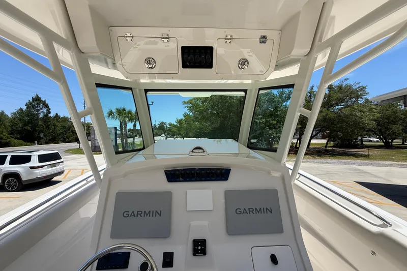 Slide: The Image of 2026 Sailfish 312 CC boat cockpit with Garmin navigation system, parked outdoors. - 15