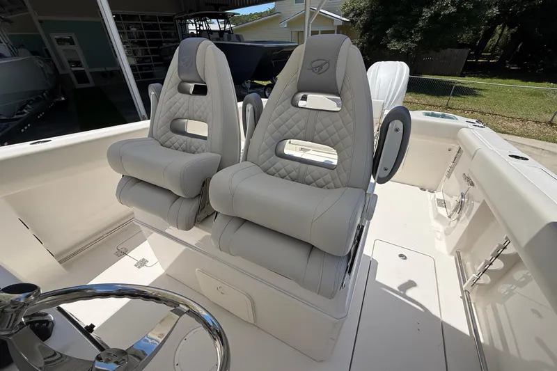 Slide: The Image of 2026 Sailfish 312 CC boat interior with luxurious, quilted gray seats and steering wheel. - 16