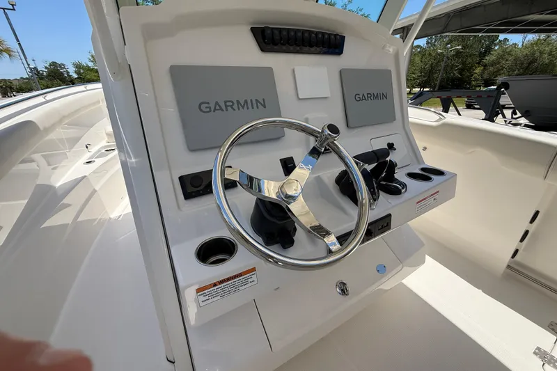 Slide: The Image of 2026 Sailfish 312 CC boat helm with Garmin navigation systems and sleek steering wheel. - 18