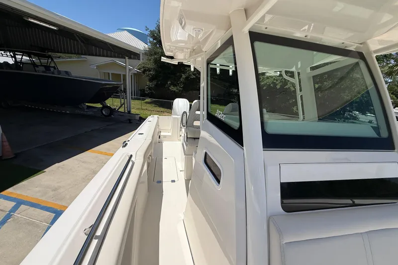 Slide: The Image of 2026 Sailfish 312 CC boat docked, showcasing sleek design and spacious deck. - 23