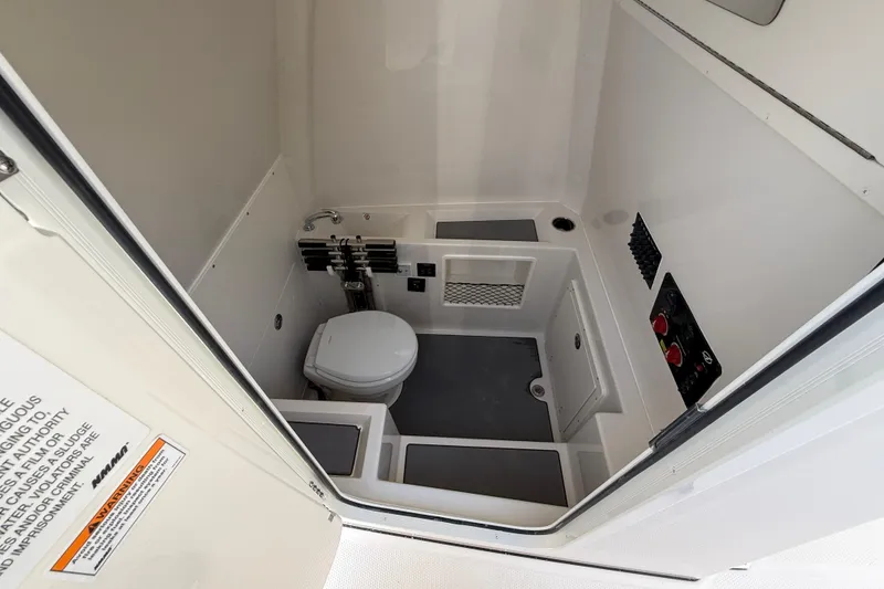 Slide: The Image of Interior of 2026 Sailfish 312 CC boat bathroom with toilet and storage compartments. - 24