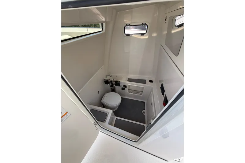 Slide: The Image of 2026 Sailfish 312 CC boat interior with compact bathroom, featuring a toilet and small window. - 25