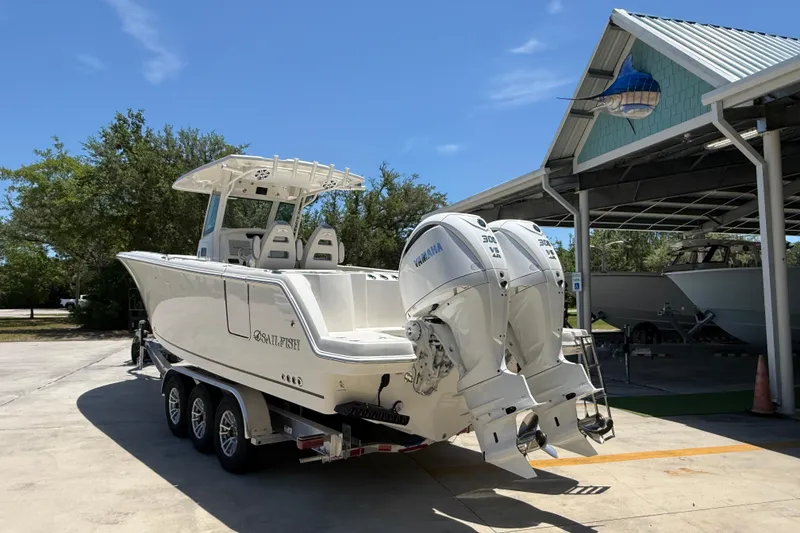 Slide: The Image of 2026 Sailfish 312 CC boat with dual Yamaha engines on a trailer, parked outdoors. - 3