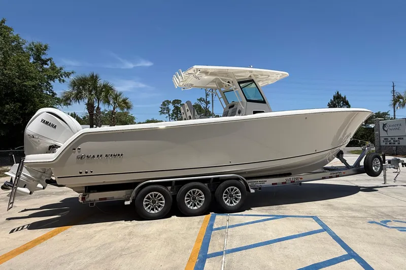 Slide: The Image of 2026 Sailfish 312 CC boat on trailer, featuring Yamaha engines, parked outdoors. - 6