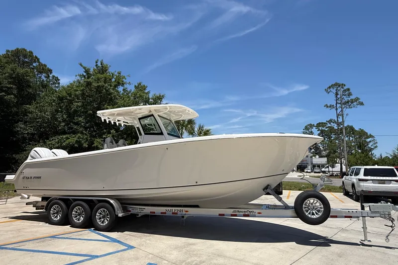 Slide: The Image of 2026 Sailfish 312 CC boat on trailer, parked outdoors under clear blue sky. - 7
