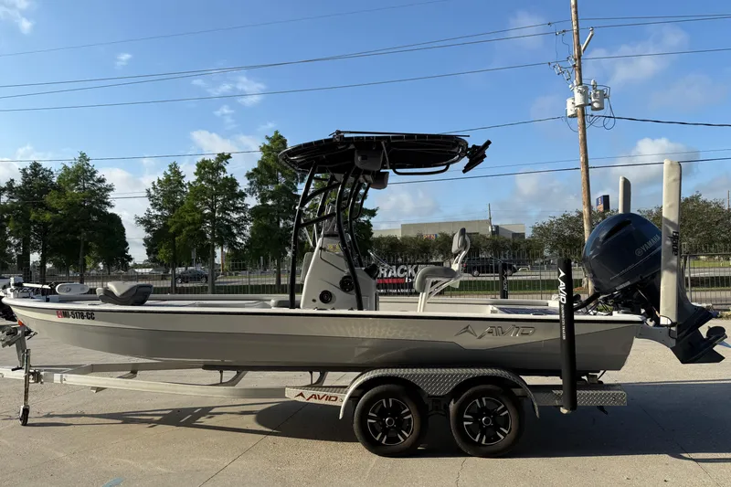 Slide: The Image of 2022 Avid 23 FS Magnum boat on trailer, parked outdoors under blue sky. - 10