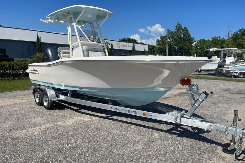 Slide: The Image of 2026 Pioneer 220 Bay Sport boat on trailer, parked outdoors under clear blue sky. - 13