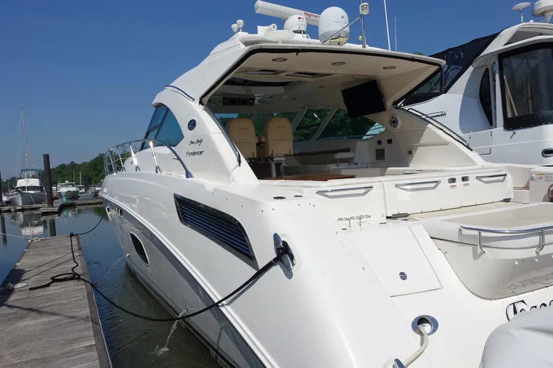 Slide: The Image of 2012 Sea Ray Sundancer 540 yacht docked at marina, showcasing sleek design and spacious deck. - 24