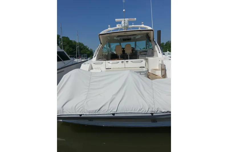 Slide: The Image of 2012 Sea Ray Sundancer 540 yacht docked, rear view with covered deck, clear sky background. - 25