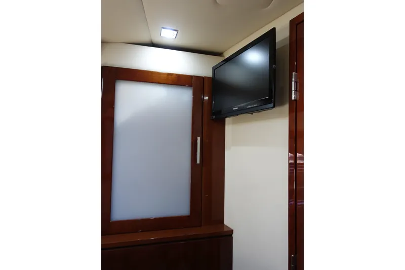 Slide: The Image of Interior of 2012 Sea Ray Sundancer 540 with mounted TV and wooden cabinetry. - 43