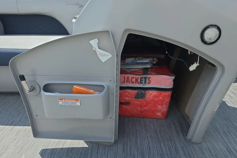 Slide: The Image of Open storage compartment on 2022 Bennington L 21 L-Bench boat with life jackets inside. - 19