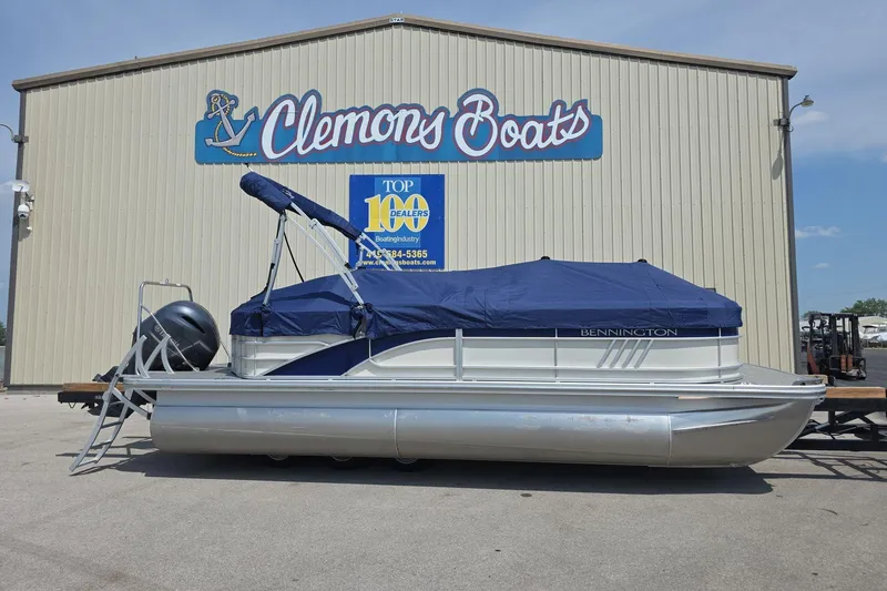 Slide: The Image of 2022 Bennington L 21 L-Bench pontoon boat with blue cover at Clemons Boats dealership. - 5