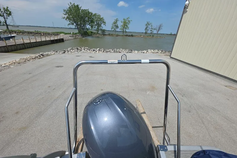 Slide: The Image of 2022 Bennington L 21 L-Bench boat at dockside with scenic lake view. - 7
