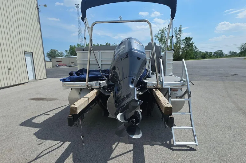 Slide: The Image of 2022 Bennington L 21 L-Bench pontoon boat with Yamaha outboard motor, parked outdoors. - 8