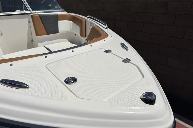 Slide: The Image of 2023 Chaparral 23 SSi boat interior with white and tan seating, sleek design. - 11