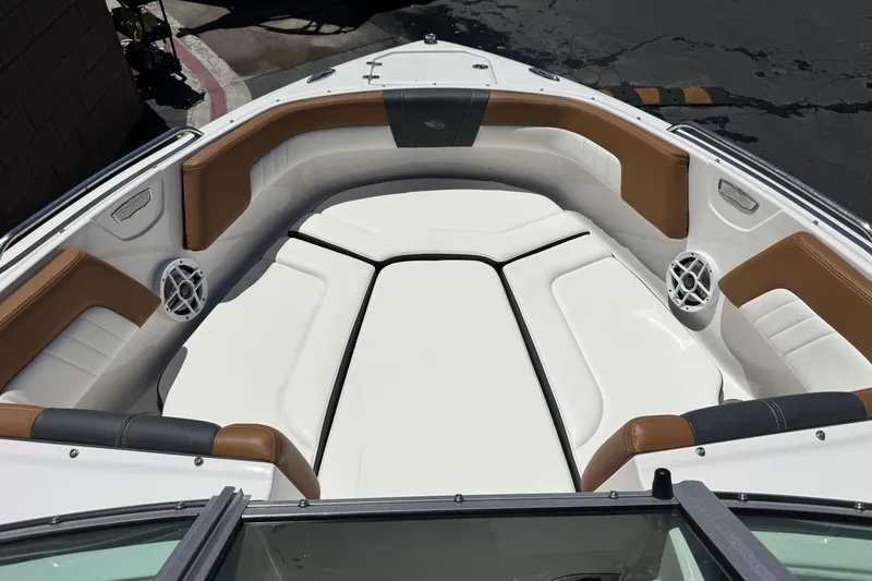 Slide: The Image of 2023 Chaparral 23 SSi boat interior with white and brown seating, featuring speakers. - 14