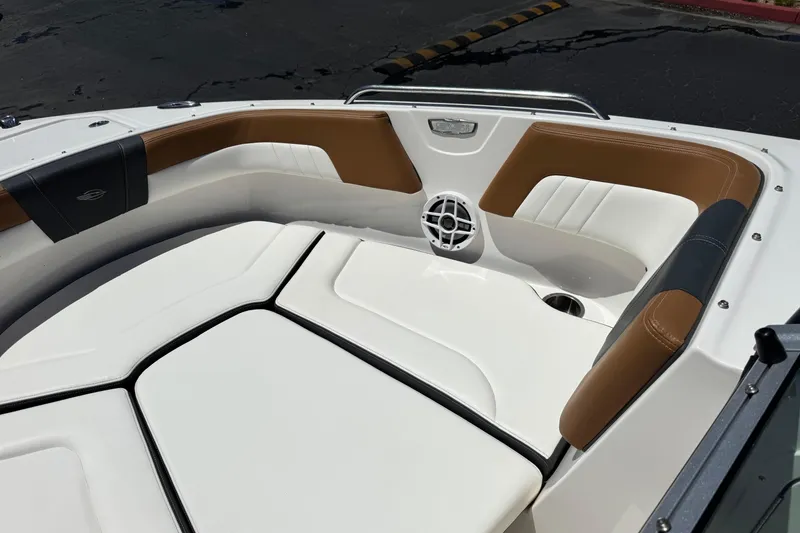 Slide: The Image of 2023 Chaparral 23 SSi boat interior with white and brown seating, speaker, and cup holder. - 16