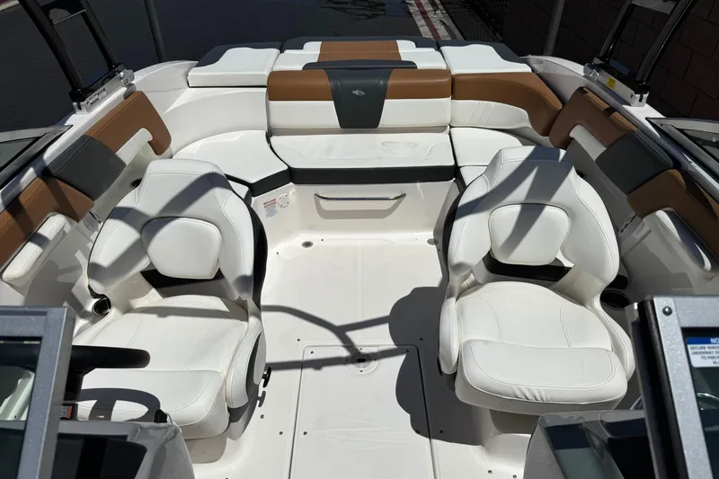Slide: The Image of 2023 Chaparral 23 SSi boat interior with white and brown seating arrangement. - 18