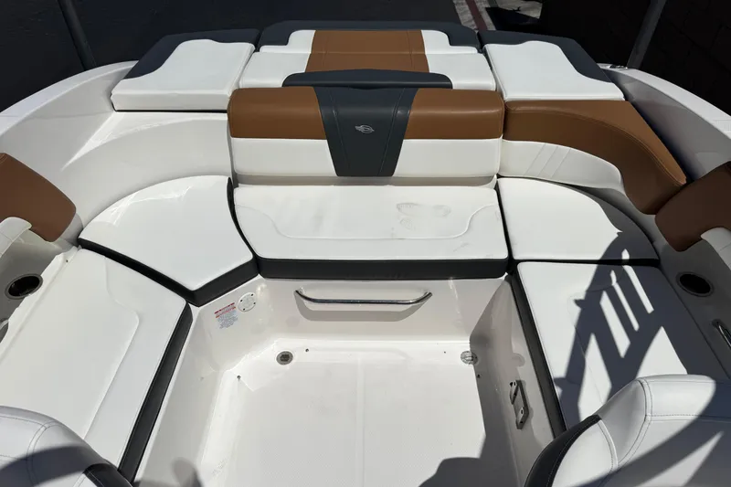 Slide: The Image of 2023 Chaparral 23 SSi boat interior with white and brown seating arrangement. - 19