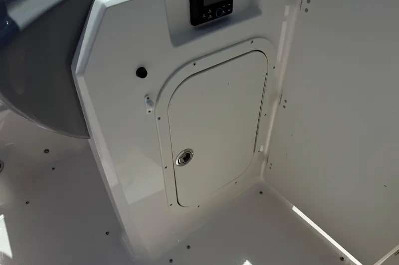Slide: The Image of 2023 Chaparral 23 SSi boat interior storage compartment with control panel. - 27