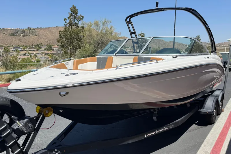 Slide: The Image of 2023 Chaparral 23 SSi boat on trailer, parked outdoors with scenic background. - 3