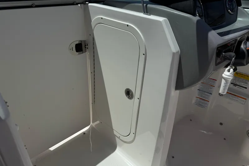 Slide: The Image of 2023 Chaparral 23 SSi boat interior showing storage compartment and control panel. - 34